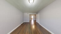 Located at 620 Bruce St, Unit B in Ridgefield, NJ, this two-bedroom, one-bathroom residence offers a well-organized single-floor layout designed for comfortable everyday living. Rich, dark hardwood floors extend throughout the main living areas and bedrooms, providing a warm and cohesive aesthetic against the soft gray-toned walls and crisp white trim.

The spacious living room provides an open and airy feel, flowing naturally into a separate dining area. The kitchen features light wood cabinetry, a gas range, a refrigerator, tiled backsplash, and light wood-look flooring, with a door offering access to natural light. A dedicated laundry area adds everyday convenience.

Both bedrooms are comfortably sized with natural light from windows that look out onto greenery. The primary bedroom is a generous retreat, while the second bedroom also features a closet. The unit is notably well-equipped with five closets in total, providing exceptional storage throughout.

The bathroom includes a full tub-shower combination with white subway-style tile surround, a natural light window, and a wood-trimmed vanity. A connecting hallway ties all rooms together efficiently. The overall ambiance is clean, neutral, and move-in ready, making this a practical and inviting home in Ridgefield, NJ.