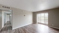 Located at 2800 John West Rd in Dallas, TX, this single-story unit offers a clean, updated interior with a cohesive neutral color palette and wood-look plank flooring carried consistently throughout. The living area is open and well-lit, with a large window fitted with blinds that brings in natural light and offers outdoor views. A ceiling fan with a light fixture overhead adds both function and comfort to the adjoining space, which flows directly into the kitchen.

The kitchen is efficiently designed in a galley layout, featuring white shaker-style cabinetry, granite-look countertops, a double stainless steel sink, and white subway tile backsplash. Stainless steel appliances, including a range, microwave, and dishwasher, complete the space.

The bedrooms are generously sized, each with neutral taupe walls, wood-look flooring, and windows that allow natural light to filter in. Closet access is present in the bedroom areas. The bathroom includes a full tub and shower combination with large-format gray tile surround, a granite-top vanity, and clean white fixtures, offering a functional and updated design. Overall, the unit presents a well-maintained, move-in-ready interior.