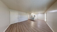 This one-bedroom, one-bathroom residence at 1762 Hogan Dr in Kokomo, Indiana, offers a well-designed single-floor layout that maximizes functionality and comfort. The open-concept living and kitchen area greets you upon entry, featuring durable wood-style flooring, neutral-toned walls, and a textured ceiling that carries throughout the main living spaces. The kitchen is thoughtfully appointed with white shaker-style cabinetry, light quartz countertops, a classic subway tile backsplash, a stainless steel refrigerator, electric range, and built-in microwave — all centered around a convenient peninsula that connects the kitchen to the living area. Natural light flows into the living room through a window overlooking the outdoors. The bedroom is carpeted for warmth and comfort, with two windows that allow ample natural light, complemented by a generously sized walk-in closet outfitted with wire shelving on multiple levels. The bathroom includes a full tub-shower combo with clean white surroundings. A dedicated in-unit laundry room with side-by-side washer and dryer hookups and additional shelving adds everyday convenience to this practical and move-in-ready home.