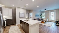 Located at Chartwell Court in Spring Hill, Tennessee, this well-appointed 2-bedroom, 2-bathroom residence offers a thoughtfully designed single-floor layout with modern finishes throughout. The open-concept kitchen and living area serves as the heart of the home, showcasing a large central island with a white quartz countertop, dark espresso cabinetry, stainless steel appliances, and recessed lighting. The kitchen flows seamlessly into the bright and welcoming living room, which features warm wood-look flooring, a ceiling fan, and access to natural light through multiple windows and a glass exterior door. Both bedrooms are comfortably sized, with the primary suite offering a serene retreat complete with its own en-suite bathroom featuring a white quartz vanity, dark cabinetry, and a marble-tiled shower. The second bathroom mirrors the same refined aesthetic with a tub-shower combo finished in marble-style tile. Four closets, including a walk-in with wire shelving systems, provide generous storage throughout. Neutral tones, clean lines, and consistent wood-look flooring tie the entire space together, creating a cohesive and contemporary living environment.