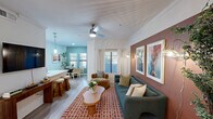 Located at 901 E Van Buren St in Phoenix, AZ, this well-appointed single-story home offers three bedrooms, two bathrooms, and a thoughtfully designed layout. The living room makes a strong first impression with a textured ceiling, crown molding, warm terracotta accent wall, light wood flooring, and a large window that invites natural light. The open-concept kitchen features white cabinetry, a white quartz peninsula with bar seating, stainless steel appliances including a refrigerator, microwave, and electric range, complemented by subway tile backsplash and pendant lighting. The dining area is framed by a sage green accent wall and multiple windows offering outdoor views, creating a bright and welcoming atmosphere. The primary bedroom includes a ceiling fan, a coordinating sage accent wall, and ample natural light from a window with blinds. Both bathrooms are finished with white vanities, large mirrors, wood-look tile flooring, and shower-tub combinations. The hallways provide smooth transitions between the living spaces and three closets offer generous storage throughout. Crown molding and consistent light wood flooring tie the home together, while the overall design balances a modern, eclectic aesthetic with functional comfort.