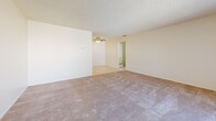 Located at 550 Yucca Ave in Barstow, California, this single-story, one-bedroom, one-bathroom unit offers a functional and straightforward layout across a compact yet efficient floor plan. The living room serves as the welcoming heart of the home, featuring neutral-toned carpet, a textured ceiling, a ceiling fan, and a large window dressed with vertical blinds that allows natural light to fill the space. The front entry opens directly into this area, creating an open and accessible feel. Adjacent to the living room, the galley-style kitchen is efficiently organized with warm wood cabinetry — both upper and lower — white laminate countertops, a stainless steel double sink, tile flooring, and standard appliances including a gas range and refrigerator. A hallway connects the main living area to the private quarters, leading to the bedroom, which is a comfortable size with plush carpeting, a textured ceiling, a window with vertical blinds, and access to a closet. The full bathroom is clean and practical, featuring tile flooring, a single-sink vanity with wood cabinetry, a toilet, and a tub/shower combination with chrome fixtures. Throughout the unit, neutral walls and light tones create a consistent, understated aesthetic.