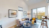 Located at 4915 N Vancouver Ave in Portland, OR, this thoughtfully designed one-bedroom, one-bathroom unit offers a modern living experience with impressive architectural details throughout. The open-concept kitchen and living area is anchored by dramatic vaulted ceilings that create a sense of spaciousness well beyond the unit's compact footprint. Light wood-tone flooring runs through the main living space, complementing the bright, white walls and large sliding glass door that opens to a private balcony with scenic views of the surrounding tree-lined neighborhood.

The kitchen features white shaker cabinetry, a subway tile backsplash, quartz countertops, and a full suite of stainless steel appliances including a range, microwave, dishwasher, and refrigerator. A wall-mounted mini-split system provides efficient climate control in the living area.

The bedroom is a calm, carpeted retreat with its own tall ceilings, a closet, and a window that brings in natural light. Two closets provide ample storage throughout the unit. The bathroom is clean and functional, finished with a walk-in shower and a stacked in-unit washer and dryer — a convenient and practical feature. The balcony offers pleasant outdoor views of mature trees and the surrounding Portland streetscape.