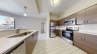 This contemporary apartment, located in AMLI Dadeland, Miami, offers a well-designed living space of 950 square feet. The unit features two bedrooms, including a primary bedroom of 140 square feet, and two full bathrooms. The interior showcases a neutral color palette with light gray walls and modern wood-look flooring throughout, creating a cohesive and inviting atmosphere.

The kitchen is a highlight, boasting wood-grain cabinetry, stainless steel appliances, and a subway tile backsplash. It opens to a living area with balcony access, allowing natural light to flood the space. The bathrooms feature clean lines with white tile surrounds and modern fixtures.

Both bedrooms are generously sized, with the primary bedroom offering ample space for a king-sized bed. Each room is equipped with a closet for storage. The apartment also includes a separate laundry area and additional storage solutions.

Climate control is provided via a central HVAC system, ensuring year-round comfort. The unit's layout maximizes functionality and flow, making it ideal for modern living. With its prime location and contemporary design, this AMLI Dadeland apartment offers a stylish urban lifestyle in the heart of Miami.