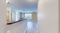 Located at 105 King Farm Blvd in Rockville, MD, this well-appointed 2-bedroom, 2-bathroom residence offers a thoughtfully designed single-floor layout. The open-concept kitchen and living area serve as the heart of the home, featuring light wood cabinetry, dark granite-style countertops, a breakfast bar peninsula, and black appliances including a gas range, microwave, and refrigerator. Light hardwood-style flooring flows seamlessly throughout the main living areas, complemented by crown molding and neutral warm-toned walls that create a bright, welcoming ambiance. Large windows in the living room flood the space with natural light and offer pleasant outdoor views of surrounding greenery. The primary bedroom is generously sized, featuring plush carpeting, a ceiling fan with light fixture, crown molding, and access to a spacious walk-in closet equipped with wire shelving. The second bedroom also offers comfortable proportions, soft carpeting, and a large window. Both bathrooms are finished with warm wood-toned vanities, white countertops, large mirrors with overhead lighting, and tile flooring. Two closets provide ample storage throughout the residence, rounding out a functional and comfortable living space.