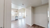 Located at Hillview Ridge Lane in Oroville, California, this 2-bedroom, 1-bathroom unit offers a thoughtfully designed single-floor layout with a clean, modern aesthetic. Light-toned walls and wood-look laminate flooring run consistently throughout, creating a cohesive and easy-to-maintain interior.

The living area stands out with notably high vaulted ceilings that amplify the sense of space. A sliding glass door floods the room with natural light and provides direct access to an outdoor area with open views of the surrounding hillside landscape.

The kitchen is well-appointed with white cabinetry, light countertops, and a full suite of stainless steel appliances including a gas range, refrigerator, and dishwasher. Recessed lighting and windows with blinds enhance both functionality and brightness.

Both bedrooms feature neutral walls, wood-look flooring, and windows that invite natural light. The primary bedroom includes panel-style white doors and ample wall space for furnishing flexibility.

The bathroom is equipped with accessibility features, including grab bars near the toilet, a vanity with a large mirror, white cabinetry, and a shower-tub combination. The layout reflects a practical and accessible design throughout the entire unit.