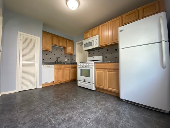 Kitchen with refrigerator, gas oven, gas stove, microwave, and dishwasher. Room for small table. - 2021 Bonner St