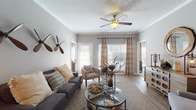 This single-story residence at 10 Kenley Way in Birmingham, Alabama offers a thoughtfully designed layout with warm, neutral tones throughout. The living room serves as the heart of the home, featuring crown molding, a textured ceiling with a ceiling fan, and large windows with plantation shutters that invite generous natural light. Wood-look flooring flows through the main living areas, adding warmth and continuity.

The dining area is a defined, intimate space with rich hardwood-style flooring, crown molding, and a pendant light fixture overhead. The kitchen is equipped with gray cabinetry, light stone countertops, and black appliances, offering a functional and stylish cooking environment.

The primary bedroom is a serene retreat with plush carpet, a ceiling fan, and ample natural light filtering through large windows with sheer curtains. An en-suite bath connects directly to the bedroom and features dual vanities with extended counter space, wood-look flooring, and a separate water closet for added privacy. A second bedroom also features carpet flooring, a ceiling fan, and its own well-sized bathroom with a single vanity and hardwood-style flooring.

Throughout the home, consistent finishes, neutral gray walls, and crown molding details contribute to a cohesive and comfortable living environment.