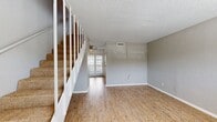 This two-story apartment offers a blend of comfort and functionality within its 630 square feet. The ground floor, spanning 320 square feet, features an open-concept living area with a combined kitchen and living room. The kitchen is equipped with modern appliances, including a stainless steel refrigerator and stove, complemented by white cabinetry and granite countertops. The living area boasts wood-look flooring and large windows that allow ample natural light, creating a bright and inviting atmosphere.

A staircase leads to the 300-square-foot upper level, where you'll find the spacious 160-square-foot primary bedroom. This room is carpeted for comfort and includes a ceiling fan for improved air circulation. The bathroom, while compact, offers essential amenities including a toilet and bathtub-shower combination.

Throughout the apartment, neutral-toned walls provide a versatile backdrop for personal decor. The space is further enhanced by convenient features such as multiple closets for storage, and ceiling fans in main living areas. Large windows in both the living room and bedroom offer views of the surrounding area, contributing to the apartment's open and airy feel. This well-designed layout maximizes the available space, making it an ideal choice for those seeking a comfortable, modern living environment.
