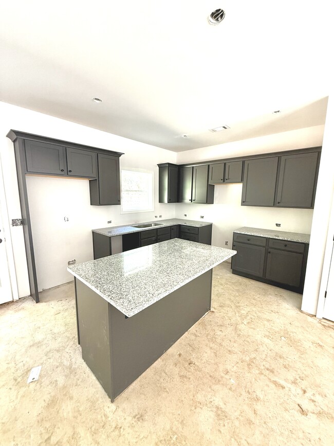 Large kitchen with granite countertops and island. Plenty of cabinet space. - Stephens Court Townhomes