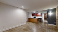 Located at 219 E Bank St in Petersburg, VA, this one-bedroom, one-bathroom unit offers an efficient and thoughtfully designed single-floor layout that balances industrial charm with contemporary updates. The open-concept living area seamlessly connects the living room, dining space, and kitchen, all unified by polished concrete floors that run throughout the unit. A central kitchen island anchors the space, complemented by rich cherry wood cabinetry, white countertops, stainless steel appliances — including a range, built-in microwave, and dishwasher — and track lighting overhead. Exposed brick walls add a striking architectural detail, lending warmth and historic character to the modern interior. The bedroom is a comfortable size, featuring a window that brings in natural light, access to a closet, and a dedicated electrical panel. The full bathroom includes a soaking tub with shower surround. A dedicated laundry area with side-by-side washer and dryer connections provides added convenience. Two closets offer practical storage throughout the unit. The overall ambiance is urban and character-rich, making it an ideal space for those who appreciate the aesthetic of historic architecture paired with updated, functional living.