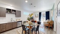 Located at 3480 Todos Santos St in Santa Fe, NM, this one-bedroom, one-bathroom residence offers a thoughtfully designed single-level layout that maximizes every square foot. The kitchen is a standout feature, showcasing rich, wood-toned cabinetry with brushed metal hardware, crisp white countertops, a stainless steel sink, and a full suite of stainless steel appliances including a refrigerator, range, microwave, and dishwasher. Light wood-style flooring runs throughout, lending warmth and continuity to the space. An adjacent dining area comfortably accommodates a small table, making the kitchen and dining zone feel open and connected. The bedroom offers a cozy, well-proportioned retreat with a window that invites natural light, complemented by neutral white walls that provide a clean backdrop. A dedicated closet adds practical storage. The bathroom features a tub/shower combo, toilet, and light wood-style flooring consistent with the rest of the home. Throughout the residence, the design aesthetic reflects a modern Southwestern sensibility — clean lines paired with warm earth tones — fitting for its Santa Fe surroundings. The single-floor plan ensures seamless flow between all rooms, making this a functional and well-appointed home.