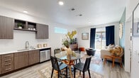 Located at 3480 Todos Santos St in Santa Fe, NM, this one-bedroom, one-bathroom residence offers a thoughtfully designed single-level layout that maximizes every square foot. The kitchen is a standout feature, showcasing rich, wood-toned cabinetry with brushed metal hardware, crisp white countertops, a stainless steel sink, and a full suite of stainless steel appliances including a refrigerator, range, microwave, and dishwasher. Light wood-style flooring runs throughout, lending warmth and continuity to the space. An adjacent dining area comfortably accommodates a small table, making the kitchen and dining zone feel open and connected. The bedroom offers a cozy, well-proportioned retreat with a window that invites natural light, complemented by neutral white walls that provide a clean backdrop. A dedicated closet adds practical storage. The bathroom features a tub/shower combo, toilet, and light wood-style flooring consistent with the rest of the home. Throughout the residence, the design aesthetic reflects a modern Southwestern sensibility — clean lines paired with warm earth tones — fitting for its Santa Fe surroundings. The single-floor plan ensures seamless flow between all rooms, making this a functional and well-appointed home.