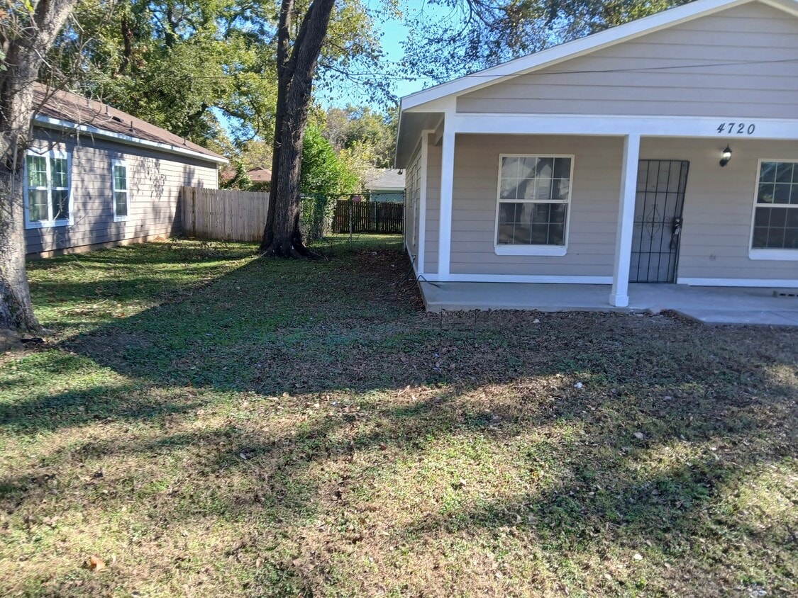 Hermosa casa color beige con detalles blancos y un amplio jardín delantero. - 4720 Burma Rd