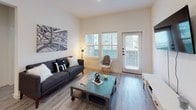 This thoughtfully designed 2-bedroom, 2-bathroom residence combines modern aesthetics with functional living across a single floor. Light-toned luxury vinyl plank flooring flows throughout, complementing the clean, neutral color palette that gives the space a bright and airy feel.

The kitchen is a standout feature, boasting white shaker-style cabinetry, granite countertops, and a classic white subway tile backsplash. Stainless steel appliances — including a refrigerator with ice maker, range, microwave, and dishwasher — complete the space. An entryway with a built-in mudroom area sits just beyond, adding everyday convenience.

The living room is welcoming and well-lit, with multiple windows and a glass-paned exterior door that draws in natural light and provides outdoor access. Both bedrooms are comfortably sized with large windows, ceiling fans, and ample natural light. The primary bedroom features access to a spacious walk-in closet with multi-tier shelving and a private en-suite bath with large-format tile, a soaking tub, and a separate glass-enclosed shower. The second bathroom offers a walk-in glass shower with built-in shelving and modern matte black fixtures. Throughout, the design balances clean modern lines with warm, livable finishes.