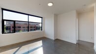 Located at 309 E 15th St in Vancouver, Washington, this modern single-floor unit showcases a clean, contemporary design throughout. The open-concept kitchen is equipped with stainless steel appliances, including a gas range and microwave, complemented by white cabinetry, light wood upper shelving, and a striking hexagonal tile backsplash. Polished concrete flooring runs through the kitchen and hallway areas, lending an industrial-chic aesthetic to the space.

The living areas feature sleek dark hardwood-style flooring and expansive black-framed windows that flood the rooms with natural light while offering views of the surrounding urban landscape. The bright white walls and clean lines create a minimalist, airy ambiance throughout.

A well-appointed hallway connects the living spaces, featuring polished floors, recessed lighting, and a stylish sliding barn door that adds a modern-rustic accent. Two bathrooms are finished with the same signature hexagonal tile detailing seen in the kitchen. One bathroom includes a soaking tub with a tiled surround, black matte fixtures, and a double-sink vanity with a light stone countertop. The second bathroom offers a walk-in shower, a built-in linen closet, and a single vanity with matching finishes. Together, these spaces deliver a cohesive, design-forward living environment.