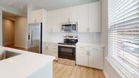 Located at 102 Kennedy Ridge Way in Mooresville, NC, this single-story, 3-bedroom, 2-bathroom home offers a clean, modern aesthetic with thoughtful finishes throughout. Light-toned luxury vinyl plank flooring runs continuously across the open-concept living and kitchen area, creating a bright and cohesive feel. The kitchen is well-appointed with white shaker-style cabinetry, white subway tile backsplash, white quartz countertops, stainless steel appliances including a refrigerator, range, and built-in microwave, and a central island that anchors the space. Natural light filters in through window blinds, adding warmth to the neutral color palette. The living area is generously sized, offering an open and airy atmosphere. Each of the three bedrooms features the same LVP flooring, soft neutral walls, and windows with views to the outdoors. The primary bedroom is comfortably sized and connects to a spacious walk-in closet outfitted with multi-level wire shelving for organized storage. Both bathrooms are finished with white subway tile tub-surround surrounds, white vanities with quartz countertops, undermount sinks, and brushed nickel fixtures. Three closets total provide ample storage throughout the home.
