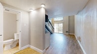 Located at 2886 S Circle Dr in Colorado Springs, CO, this two-story residence offers a well-organized layout across two floors. The main level features an open-concept living area and kitchen, where light wood-style flooring and neutral-toned walls create a clean, modern aesthetic. The kitchen is equipped with white cabinetry, a stainless steel refrigerator, a built-in microwave, and a tile backsplash, seamlessly integrating with the living space. A striking open-riser staircase with a dark metal railing serves as a visual focal point, leading the eye upward to dramatic double-height ceilings and a large window that floods the space with natural light. A sliding glass door on the main level provides additional brightness and outdoor access. The upper floor houses the primary bedroom, which benefits from windows overlooking the living area below, along with wood-style flooring and open railing that maintains the airy, connected feel of the home. Three bathrooms serve the residence; one features a soaking tub with tile surround and grab bar, while another includes a sliding-door shower stall with a white vanity. An additional bathroom on the upper level includes a vessel sink atop granite-style countertops with access to a dedicated closet. Textured ceilings are present throughout, adding character to every room.