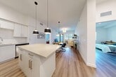 Located at 3784 West 88th Street in Hialeah, FL, this thoughtfully designed 2-bedroom, 2-bathroom residence offers a clean, contemporary aesthetic across a well-organized single-floor layout. The open-concept living and kitchen area serves as the heart of the home, featuring light hardwood-style flooring, soaring ceilings, and an abundance of natural light. The kitchen is outfitted with crisp white cabinetry, stainless steel appliances, track and pendant lighting, and a central island with bar seating — ideal for both cooking and casual dining. The space flows seamlessly into the living area, which benefits from large windows and access to an outdoor area. The primary bedroom is generously sized, offering a serene retreat with an en-suite bathroom featuring warm wood-toned cabinetry, a full soaking tub, and clean white tile finishes. The second bedroom is bright and comfortable, with wood-style flooring and ample natural light from a large window. Both bedrooms are complemented by walk-in closets equipped with wire shelving systems for organized storage. The overall ambiance is bright, modern, and airy, with a neutral color palette that creates a cohesive and welcoming atmosphere throughout.