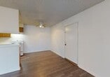 This single-floor, 3-bedroom, 2-bathroom unit offers a straightforward and functional layout designed to maximize usability. The combined kitchen and living area serves as the heart of the space, featuring durable hardwood-style flooring throughout and a ceiling fan that adds both comfort and character. The open layout allows the kitchen and living areas to flow seamlessly together, creating a versatile shared space.

The galley-style kitchen is well-equipped with warm wood cabinetry lining both walls, providing generous storage. White appliances including an electric range and refrigerator are included, along with a double sink set into a light-colored countertop, and overhead lighting to brighten the workspace.

The three bedrooms are carpeted, offering a softer underfoot feel, and are finished with neutral walls that provide a clean, move-in ready atmosphere. The primary bedroom is a comfortable size, while the additional bedrooms are well-suited for a variety of uses. A dedicated closet adds practical storage to the unit.

The two bathrooms each feature wood-toned cabinetry and light countertops. One bathroom includes a full tub and shower combo with white tile surround, while the second features a wide vanity with a large mirror. Hardwood-style flooring carries through both bathrooms, tying the overall aesthetic together cohesively.
