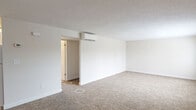 Located at 35 Robert Treat Dr in Milford, CT, this single-level, one-bedroom, one-bathroom residence offers a practical and well-organized layout. The open living room is generously proportioned, featuring wall-to-wall carpet in a warm neutral tone, crisp white walls, a textured ceiling, and a wall-mounted mini-split HVAC unit providing efficient climate control. Natural light filters in through a window, adding brightness to the space.

The kitchen is thoughtfully designed with white shaker-style cabinetry, dark granite-style countertops, a stainless steel sink, and tile flooring. A window above the counter brings in natural light, while included appliances — a refrigerator, range, dishwasher, and over-the-range microwave — make the space fully functional.

The bedroom is a comfortable, carpeted room with a window offering an exterior view, a wall-mounted thermostat, and a classic six-panel closet door providing ample storage.

The full bathroom is finished with light tile flooring, white subway tile surrounding the tub/shower combination, and a window that allows natural ventilation and light. Clean white fixtures and a baseboard heater complete the space. Overall, the residence presents a clean, move-in-ready interior with consistent finishes throughout.