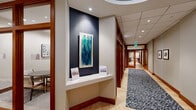 Located at 2 Center St in Newark, NJ, this expansive amenity floor offers a thoughtfully designed suite of spaces spread across a single, generously proportioned level. The entrance corridor sets an elegant tone with warm wood-trimmed doorways, light hardwood flooring, a patterned area runner, and curated wall art displayed against a bold accent wall.

The fitness facilities are a standout feature, comprising a fully equipped exercise room with cardio machines, cycling bikes, a cable machine, and a striking city skyline mural as a backdrop. An adjoining studio space with floor-to-ceiling mirrors, hardwood flooring, free weights, and a large mounted display provides a versatile area for group or individual training.

The living room offers a welcoming lounge environment with hardwood floors, tasteful furnishings, and floor-to-ceiling glass doors opening to an outdoor terrace. The game room provides recreational space complete with a billiard table, ping-pong table, and wall-mounted television. The dedicated office features a long built-in workstation, integrated shelving, and framed architectural photography.

A full kitchen and bar area showcases rich wood cabinetry, a white quartz countertop with seating, stainless steel appliances, and lush indoor plants. Four well-appointed bathrooms, including a spacious tiled walk-in shower, complete this comprehensive amenity floor.