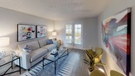 This single-story unit offers a thoughtfully designed layout with two bedrooms, two bathrooms, a living room, dining area, and a galley-style kitchen. The living room features wood-look flooring, neutral gray walls, a textured ceiling, and French doors that invite natural light and provide outdoor access. Adjacent to the living room, the dining area includes a ceiling fan and a window overlooking the outdoors, enhancing the sense of openness.

The galley kitchen is efficiently organized with white cabinetry, gray subway tile backsplash, quartz-style countertops, a stainless steel sink, and stainless steel appliances, including a refrigerator and range. Wood-look flooring runs throughout the kitchen, complementing its clean, contemporary aesthetic.

Both bedrooms feature plush carpet, textured ceilings, and neutral walls. One bedroom includes a window with outdoor views, while both offer closet storage. The bathrooms are well-appointed; one features a double-sink vanity with quartz-style countertops, white cabinetry, and wood-look flooring, while the second includes a tub-shower combination with white tile surround and a striped curtain. Together, these spaces create a cohesive, functional, and modern living environment.