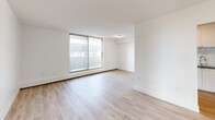 Located at 1200 Talwood Crt in Peterborough, Ontario, this well-designed 3-bedroom, 2-bathroom unit offers a comfortable and functional single-floor layout. The interior is finished with light-toned hardwood flooring throughout, crisp white walls, and clean baseboard detailing that give the space a bright, modern aesthetic.

The spacious living room is bathed in natural light from a large sliding glass door that opens onto a private balcony, offering outdoor views of the surrounding neighbourhood. The kitchen is thoughtfully appointed with white shaker-style cabinetry, dark countertops, a subway tile backsplash, stainless steel appliances including a full-sized refrigerator and dishwasher, and a double sink — providing both style and practicality.

The three bedrooms are well-proportioned and filled with natural light, each featuring the same warm hardwood flooring. The primary bedroom offers a generous footprint with ample space for furnishings. Both bathrooms are finished in a clean, contemporary style — one featuring a white vanity with chrome fixtures and a backlit mirror, and the other showcasing a full tub surround clad in classic white subway tile. A dedicated closet and hallway complete the functional floor plan of this move-in-ready unit.