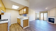Located in Vista, California, this well-appointed one-bedroom, one-bathroom residence offers a thoughtfully designed single-floor layout that maximizes its comfortable footprint. Wood-style plank flooring runs throughout the entire home, providing a cohesive and easy-to-maintain aesthetic.

The open-concept kitchen flows seamlessly into the living area, creating an inviting, connected space. The kitchen is equipped with warm oak-toned cabinetry, white appliances including a gas range and dishwasher, a white countertop with an integrated sink, and a skylight overhead that fills the space with natural light. A peninsula counter adds additional workspace and visual separation from the living area.

The living room is bright and welcoming, featuring a corner fireplace with a clean white surround, a sliding glass door that opens to an outdoor balcony, and a large window that brings in additional natural light. A textured ceiling and recessed lighting complete the space.

The spacious primary bedroom includes a window with outdoor views and a textured ceiling, offering a calm retreat. A dedicated walk-in closet provides generous built-in shelving and hanging rods for ample storage.

The bathroom is fully functional, featuring a combination tub and shower, a vanity with a wood cabinet base and speckled countertop, a large mirror, and wood-style flooring consistent with the rest of the home.