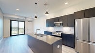 This contemporary residence in Oakdale, MN, offers 940 square feet of thoughtfully designed living space. The single-story layout includes three bedrooms, with the primary bedroom boasting 150 square feet. The home features two full bathrooms, both outfitted with modern fixtures and ample storage.

The heart of the home is an open-concept kitchen and living area. The kitchen showcases dark cabinetry, stainless steel appliances, and a large center island, perfect for meal preparation and casual dining. Pendant lighting adds a touch of sophistication to the space.

Throughout the home, light-toned wood-look flooring creates a seamless flow and enhances the bright, airy ambiance. Large windows in the bedrooms and living areas flood the space with natural light and offer scenic views of the surrounding landscape.

The bedrooms are generously sized, with the primary bedroom featuring a closet for storage. The bathrooms are designed with practicality in mind, featuring white fixtures and neutral tones that complement the home's modern aesthetic.

This property's efficient use of space, contemporary design elements, and prime location in Oakdale make it an attractive option for those seeking a stylish and functional living environment.