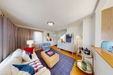 Located at 62 Macarthur Circle East in South Portland, Maine, this cheerful three-floor home offers a well-organized layout across its levels. The main floor features a welcoming living room with warm hardwood floors, natural light from street-facing windows, and a front entry that opens to a cozy seating area accented by nautical-themed artwork. The kitchen is well-equipped with stainless steel appliances, honey-toned wood cabinetry, granite-style countertops, and charming oyster-print wallpaper that adds a coastal character. Tile flooring and ample cabinet storage complete the functional space.

Upstairs, the primary bedroom is generously proportioned, featuring hardwood floors, multiple windows with views of the surrounding greenery, and a relaxed, airy feel. The second bedroom makes a bold design statement with a striking blue checkerboard accent wall, hardwood floors, a closet, and a window providing natural light. The full bathroom is clean and functional, featuring a tub-shower combination with classic finishes. A utility room rounds out the practical amenities. Outside, the property is set on a quiet residential street with mature trees and well-maintained greenery, contributing to its peaceful New England neighborhood charm.