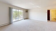 Located at 1391 Oak Brook Dr. in North Royalton, Ohio, this two-bedroom, one-bathroom unit offers a well-organized single-floor layout designed for comfortable everyday living. The floor plan connects a hallway entry, kitchen, two bedrooms, and a full bathroom in a practical and functional arrangement.

The generously sized primary bedroom is among the most notable features of the unit, offering plush carpeting, a textured ceiling, a large window that invites natural light, and a baseboard heating system. A wide sliding closet with mirrored-style panel doors provides ample storage. The second bedroom also features carpet flooring, a window with outdoor greenery views, and its own baseboard heater.

The living area is bright and open, highlighted by a full-width sliding glass door that opens to a balcony overlooking lush tree coverage. A wall-mounted air conditioning unit and baseboard heating ensure year-round comfort. The entry area features warm hardwood flooring beneath a solid wood front door.

The galley-style kitchen is efficiently designed with warm honey-toned cabinetry lining both walls, laminate countertops, a stainless steel sink, and white appliances including a range and refrigerator, all set atop light hardwood-style flooring.

The full bathroom is clean and classic, featuring white subway tile surrounding a tub-shower combo, a white toilet, vanity, and small-format tile flooring.