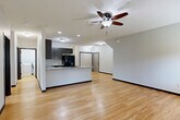 Located at 15707 Grand Plaza in Omaha, Nebraska, this well-appointed single-floor home offers three bedrooms, two bathrooms, and a thoughtfully designed layout that maximizes comfort and functionality. The open-concept main living area seamlessly connects the living room, dining space, and kitchen, all finished with warm light hardwood flooring and ceiling fans. The kitchen is a standout, featuring dark espresso cabinetry, granite-look countertops, a breakfast bar peninsula, and black appliances including a refrigerator, range, and built-in microwave. The bathrooms are finished with large-format tile flooring, dark wood vanities, granite countertops, and generous storage. Each bedroom is carpeted and equipped with a ceiling fan and natural light from windows with views of surrounding greenery. The primary bedroom is generously sized with dedicated closet space. Throughout the home, six closets provide exceptional storage capacity, complemented by a dedicated laundry room with a full-size washer and dryer. An attached garage adds everyday convenience. The clean, neutral palette and modern finishes create a move-in-ready, comfortable living environment throughout.