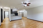 Located at 15707 Grand Plaza in Omaha, Nebraska, this well-appointed single-floor home offers three bedrooms, two bathrooms, and a thoughtfully designed layout that maximizes comfort and functionality. The open-concept main living area seamlessly connects the living room, dining space, and kitchen, all finished with warm light hardwood flooring and ceiling fans. The kitchen is a standout, featuring dark espresso cabinetry, granite-look countertops, a breakfast bar peninsula, and black appliances including a refrigerator, range, and built-in microwave. The bathrooms are finished with large-format tile flooring, dark wood vanities, granite countertops, and generous storage. Each bedroom is carpeted and equipped with a ceiling fan and natural light from windows with views of surrounding greenery. The primary bedroom is generously sized with dedicated closet space. Throughout the home, six closets provide exceptional storage capacity, complemented by a dedicated laundry room with a full-size washer and dryer. An attached garage adds everyday convenience. The clean, neutral palette and modern finishes create a move-in-ready, comfortable living environment throughout.