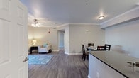 Located at 1168–1178 Corporate Way in Sacramento, California, this single-floor residence offers a thoughtfully designed layout with modern finishes throughout. The open-concept living and dining area serves as the heart of the home, featuring wood-style flooring, crown molding, and a ceiling fan that enhances both comfort and style. A sliding glass door in the living room floods the space with natural light and provides direct access to a private outdoor balcony. The dining area offers a defined space ideal for everyday meals or entertaining guests. The kitchen is outfitted with white cabinetry, dark granite-style countertops, a stainless steel dishwasher, and a deep undermount sink — combining functionality with a clean, contemporary aesthetic. Bedrooms are carpeted for comfort and include generous closet space, with one bedroom featuring a walk-in closet. Natural light filters in through windows with blinds in each bedroom, creating a bright and welcoming atmosphere. The bathroom is well-appointed with a wide vanity, dark countertop, white cabinetry, a large mirror, and a full soaking tub with shower. Neutral tones and consistent finishes throughout the home contribute to a cohesive and inviting overall ambiance.