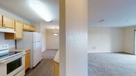 Located within the Lake Pointe Village community in Orlando, Florida, this single-floor residence offers a well-organized layout designed for comfortable everyday living. The kitchen is outfitted with warm honey-toned wood cabinetry, light countertops, wood-look vinyl flooring, and includes a full suite of appliances—among them a refrigerator and electric range. A built-in pantry closet and ample cabinet storage provide practical functionality throughout the space.

The open living area features plush carpeting and neutral wall tones, creating a bright, welcoming atmosphere. A sliding glass door leads to a private balcony, extending the living space outdoors. A dedicated dining area with a pendant light fixture sits adjacent to the kitchen, offering a clear sightline through the home.

The bedrooms are carpeted and finished with neutral tones, each featuring windows that frame picturesque lake views—a standout element of this property. Crown molding accents one of the bedrooms, adding a refined architectural detail.

Two bathrooms mirror each other in style, each equipped with wood-toned vanities, light countertops, and wood-look flooring. The textured ceilings and consistent finishes throughout lend a cohesive, tidy character to the entire residence.