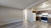 Located at 2217 Tanglewood Dr in Hammond, Indiana, this single-floor, 2-bedroom, 1-bathroom home offers a practical and comfortable layout. The interior is finished with consistent luxury vinyl plank flooring throughout, giving the space a clean, cohesive look. Neutral gray and beige tones on the walls create a calm, versatile atmosphere across all rooms.

The combined kitchen and dining area is a functional highlight, featuring dark wood cabinetry with ample upper and lower storage, light granite-style countertops, a full-size refrigerator, and an electric range. The open layout allows the kitchen to flow naturally into the dining space. Adjacent to the kitchen, the living room offers a generous, open area with room for a variety of furniture arrangements and connects via a hallway to the rest of the home.

The primary bedroom is notably spacious and includes two closets with bi-fold doors, providing substantial storage. The second bedroom features a window that brings in natural light, a closet, and baseboard heating. The shared full bathroom includes a wood-vanity with a single sink, mirrored medicine cabinet, and an adjacent linen closet with built-in shelving. A connecting hallway ties all rooms together efficiently, completing this well-organized, move-in-ready home.