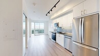 Located at 2215 Sheridan Park Drive in Mississauga, this modern 1-bedroom, 1-bathroom unit offers a thoughtfully designed open-concept layout with contemporary finishes throughout. Light wood-tone laminate flooring flows seamlessly across the entire space, enhancing the bright and airy atmosphere created by large floor-to-ceiling windows and sliding glass doors.

The kitchen is well-appointed with crisp white cabinetry, grey quartz countertops, a subtle tile backsplash, and a full suite of stainless steel appliances including a Whirlpool range, built-in microwave, dishwasher, and French door refrigerator. Track lighting overhead adds a modern touch to the open living area, which transitions naturally toward the private balcony, accessible through sliding glass doors that frame expansive views of the surrounding greenery and Mississauga skyline.

The bedroom is a comfortable and well-proportioned space featuring a mirrored sliding closet and its own access to the balcony, offering peaceful outdoor views. The bathroom is finished in clean white subway-style wall tiles, featuring a soaker tub with a hand shower, a toilet, and a wood-toned vanity with a light countertop. The overall design is clean, minimalist, and move-in ready, making this unit an ideal space for modern urban living.