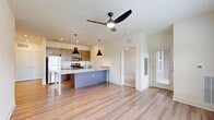 Located on Old Lynchburg Road in Charlottesville, VA, this well-appointed 2-bedroom, 2-bathroom residence offers a thoughtfully designed single-level layout. The open-concept living and kitchen area is anchored by a striking central island topped with granite countertops, complemented by sleek taupe cabinetry, stainless steel appliances, and bold pendant lighting. Light wood-style flooring flows throughout the main living areas, enhancing the bright, airy atmosphere created by natural light from large windows. A modern ceiling fan in the living room adds both function and style, while a private exterior door provides convenient outdoor access.

The two bedrooms feature plush carpeting, ceiling fans, and ample closet space with double-door closets. Windows in the bedrooms invite natural light and offer pleasant views of the surrounding greenery. The bathrooms are finished with granite-topped vanities and dark cabinetry, maintaining a consistent, modern aesthetic throughout. One bathroom includes a full soaking tub and shower combination. The overall design is clean and contemporary, with a neutral color palette that creates a welcoming and versatile living environment suited to a variety of lifestyles.