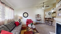 Located at 201 S Camino Seco in Tucson, Arizona, this one-bedroom, one-bathroom residence offers a well-designed single-floor layout that maximizes every square foot. The combined living and dining area forms the heart of the home, featuring vaulted ceilings, a ceiling fan with light fixture, a tile-surround fireplace, and carpet flooring. Natural light enters through a front-facing window, and the open layout flows seamlessly into the dining space, which is anchored by a breakfast bar with seating. The galley-style kitchen is fully equipped with black appliances — including an electric range, microwave, and refrigerator — complemented by light wood-trimmed cabinetry, generous counter space, a double basin sink, and tile flooring. The bedroom is a comfortable retreat featuring vaulted ceilings, carpet flooring, a window with an outdoor view, and direct access to multiple closets as well as the full bathroom. The bathroom includes a tub-shower combination with tile flooring. A hallway connects the main living areas to the private bedroom wing, and three closets throughout the unit provide ample storage. This efficiently designed home offers a functional and comfortable living environment in a convenient Tucson location.