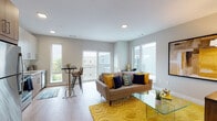 Located at 203 Concord Turnpike in Cambridge, MA, this modern single-floor residence offers a thoughtfully designed open-concept layout with clean lines and contemporary finishes throughout. Light hardwood flooring flows seamlessly across the living, dining, and kitchen areas, creating a cohesive and welcoming atmosphere.

The living area is bright and airy, benefiting from multiple windows that invite abundant natural light. A sliding glass door provides direct access to a private balcony, extending the living space outdoors. The kitchen is well-appointed with stainless steel appliances, two-tone cabinetry combining warm wood and neutral tones, a subway tile backsplash, and a dark-topped breakfast bar with seating — ideal for casual dining or entertaining.

The bedroom is a calm, understated retreat featuring hardwood flooring, soft neutral walls, and a high clerestory window that introduces natural light while maintaining privacy. The bathroom presents a clean, modern aesthetic with a wall-mounted wood vanity, white quartz countertop, a frameless mirror, and contemporary chrome fixtures. Recessed lighting throughout the residence ensures a consistently well-lit environment. The overall design balances functionality with modern style, making this Cambridge residence a refined and comfortable space.