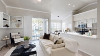 Located at 801 Legacy Dr in Plano, TX, this well-appointed 2-bedroom, 2-bathroom residence offers a thoughtfully designed single-floor layout. The open-concept living area immediately impresses with soaring vaulted ceilings adorned with crown molding, light-toned herringbone-patterned flooring, and an abundance of natural light streaming through sliding glass doors that lead to a private balcony overlooking the outdoors. The kitchen is a functional centerpiece, featuring white cabinetry, stainless steel appliances, and a generous white peninsula with an integrated sink — ideal for both meal prep and casual dining. Adjacent to the kitchen, the dining area is framed by large windows with views of the surrounding community, illuminated by a modern circular pendant light. The spacious primary bedroom offers plush carpeting, crown molding, and direct access to a sizable walk-in closet with built-in shelving. The bathrooms are finished in clean, neutral tones, with one featuring a full tub-shower combination and a window for natural light. Two closets throughout the home provide ample storage. The overall aesthetic is bright, airy, and cohesive, with a neutral color palette that creates a calm and inviting ambiance throughout.
