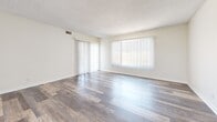 Located at 9070 Florence Ave in Downey, CA, this single-floor residence offers 2 bedrooms, 3 bathrooms, and a well-planned layout spanning a generous footprint. Wood-look plank flooring flows throughout, complementing the neutral, light-toned walls and textured ceilings found across the home.

The living room is bright and open, featuring large windows dressed with vertical blinds that invite abundant natural light. An adjacent dining area connects seamlessly to the galley-style kitchen, which is outfitted with white cabinetry, granite-style countertops, stainless steel appliances — including a refrigerator, range, and built-in microwave — and a double basin sink.

The spacious primary bedroom includes a mirrored sliding-door closet, providing ample storage and adding visual depth to the room. A second well-sized bedroom also benefits from large windows with garden views. Four closets throughout the unit ensure excellent storage capacity.

Three bathrooms serve the home; the primary bath features a dual-sink vanity with granite-style countertops, white cabinetry, and a shower-tub combo with a window for natural ventilation. Additional bathrooms offer similar clean, functional finishes. A private balcony extends the living space outdoors, offering a peaceful retreat.