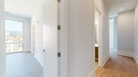 Located in Chicago's vibrant West Loop neighborhood, this modern 2-bedroom, 1-bathroom residence offers a thoughtfully designed single-floor layout with contemporary finishes throughout. Light wood-tone flooring flows seamlessly across the entire unit, complementing the clean white walls and crisp trim work that define the space's modern aesthetic.

The living areas are bathed in natural light, thanks to expansive floor-to-ceiling windows that frame breathtaking views of the Chicago skyline, including the iconic Willis Tower. These oversized windows create a strong connection between the interior and the dynamic urban landscape outside.

Both bedrooms are generously proportioned, with the primary bedroom offering impressive city views through large windows. The second bedroom also benefits from floor-to-ceiling glazing, flooding the room with natural light. A well-organized closet with built-in shelving and hanging rods provides ample storage within the bedroom.

The bathroom is elegantly appointed with a floating dual-sink vanity featuring dark wood cabinetry, white quartz countertops, a large wall mirror with modern lighting, and a glass-enclosed shower with textured tile surround.

Two hallways provide smooth circulation throughout the unit, and a dedicated closet adds additional storage. The open living areas benefit from balcony access, further enhancing the connection to the stunning Chicago cityscape.