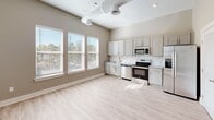 Located at 3440 Southern Ave in Memphis, TN, this one-bedroom, one-bathroom unit offers a well-designed single-floor layout with modern finishes throughout. The open-concept kitchen and living area serves as the heart of the space, featuring soaring ceilings with exposed ductwork that adds an industrial character. Large windows flood the area with abundant natural light and offer pleasant views of the surrounding greenery. The kitchen is equipped with stainless steel appliances, including a French door refrigerator, range, microwave, and dishwasher, complemented by gray shaker-style cabinetry, granite countertops, and a white subway tile backsplash. Light wood-style flooring runs throughout the unit, creating a cohesive and clean aesthetic. The bedroom is a comfortable, well-proportioned room with a large window that continues the natural light theme. A dedicated laundry area houses a stacked washer and dryer unit, adding everyday convenience. The bathroom features a vanity with granite countertops, gray cabinetry, and a mirror, maintaining the consistent modern style found throughout the unit. Additional spaces include a closet, pantry, hallway, and utility room, ensuring practical storage and functionality across the layout.