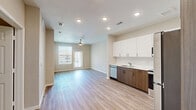 This well-appointed one-bedroom, one-bathroom residence in Conroe, TX offers a thoughtfully designed open-concept layout that seamlessly connects the living, dining, and kitchen areas. Light wood-tone luxury vinyl plank flooring flows throughout the main living spaces, complemented by neutral warm-beige walls and recessed lighting that keeps the interior bright and inviting. A ceiling fan in the living area adds comfort, while large windows and a glass door open to a private balcony overlooking the community pool, bringing in abundant natural light and outdoor views. The modern kitchen is equipped with stainless steel appliances—including a refrigerator, range, microwave, and dishwasher—paired with crisp white upper cabinets, warm wood-toned lower cabinetry, and clean white countertops. Ample tall pantry-style cabinetry provides generous storage. The bedroom features plush carpet, a ceiling fan, and a window with community views. The full bathroom includes a wood-toned vanity with a white countertop and leads directly to a spacious walk-in closet with built-in shelving. A dedicated laundry area and staircase access round out the functional layout of this contemporary Conroe residence.