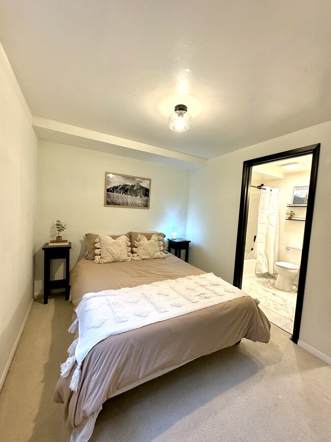 Bedroom with soft linens and en suite bathroom. - 7335 S Bainbridge Cir