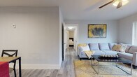 Located at McCain Park Drive in North Little Rock, Arkansas, this single-story residence offers a thoughtfully designed layout with contemporary finishes throughout. Light gray walls and wood-look luxury vinyl plank flooring create a cohesive aesthetic that flows seamlessly from room to room.

The living area is bright and welcoming, featuring a large window that allows ample natural light and views of the surrounding greenery. A ceiling fan adds comfort, and the open sightline connects the space to a hallway leading to the bedrooms. A dedicated dining area accommodates a full-sized table and benefits from overhead lighting and additional closet storage.

The kitchen is well-appointed with white shaker-style cabinetry, dark countertops, a classic subway tile backsplash, and stainless steel appliances, including a range, microwave, and dishwasher. A window above the sink brings in natural light.

The bedrooms are comfortably sized, each with large windows and ample closet space, including a spacious walk-in closet with built-in shelving and hanging rods. The bathroom features white cabinetry with a dark countertop and a shower-tub combination. A dedicated laundry area houses a full-sized washer and dryer, providing added convenience within the unit.