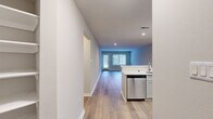 Located at 3113 Pine Orchard Ln in Ellicott City, MD, this single-floor residence offers two bedrooms and two full bathrooms within a thoughtfully designed layout. Light-toned luxury vinyl plank flooring flows throughout the main living areas, complemented by neutral gray walls and clean white trim that create a bright, cohesive aesthetic.

The kitchen is well-appointed with gray shaker-style cabinetry, white quartz countertops, and a full suite of stainless steel appliances including a refrigerator, range, built-in microwave, and dishwasher. It opens toward the living area, promoting an easy flow for everyday living. The spacious living room features large windows and a sliding glass door that floods the space with natural light and provides direct access to a private patio with wooded views beyond.

The generously sized primary bedroom is carpeted and features a sliding glass door with views of the surrounding greenery, along with a walk-in closet outfitted with wire shelving. The second bedroom is equally comfortable, with a large window and plush carpeting. Both bathrooms are finished with white cabinetry, quartz countertops, and tub-shower combinations with tiled surrounds. The unit also includes a dedicated laundry area and convenient hallway closets for additional storage.