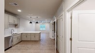 Located at 436 State Highway 30 in Port Wentworth, GA, this single-story 2-bedroom, 1-bathroom residence offers a thoughtfully designed layout with contemporary finishes throughout. Light wood-look flooring flows seamlessly across the entire unit, creating a cohesive and clean aesthetic.

The open kitchen and living area serves as the heart of the home. The kitchen is well-appointed with shaker-style cabinetry in a soft gray-white tone, white quartz countertops, a subway tile backsplash, and a full suite of stainless steel appliances including a refrigerator, range, microwave, and dishwasher. A pendant light adds a stylish accent above the counter space.

Both bedrooms are bright and comfortable, each featuring ceiling fans, recessed lighting, and windows that allow natural light to fill the rooms. The primary bedroom includes an adjacent closet for convenient storage. One bedroom also features a built-in desk, adding functional versatility.

The full bathroom is finished to a high standard, offering a walk-in tiled shower, a vanity with under-mount sink and quartz countertop, and a framed mirror. A separate closet area and in-unit washer and dryer hookups round out the practical amenities of this move-in-ready residence.
